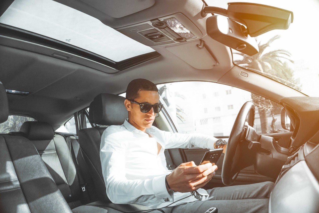 person in white shirt inside a car